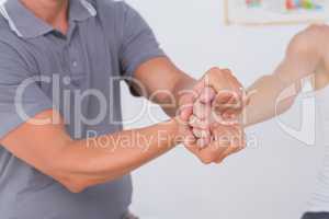 Doctor stretching a young woman arm