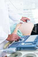 Male doctor doing ultrasound on pregnant woman