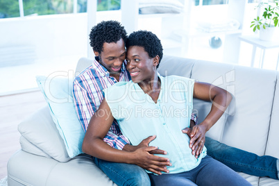 Couple embracing while sitting on couch