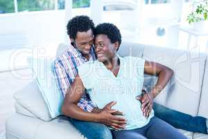 Couple embracing while sitting on couch