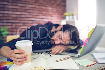 Tired creative editor holding disposable cup