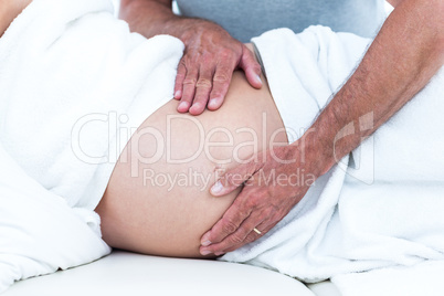 Cropped image of masseur massaging pregnant woman