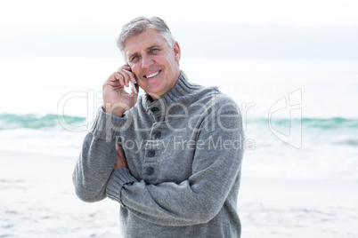 Smiling man standing and on his phone
