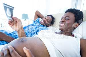 Smiling pregnant woman looking at ultrasound scan