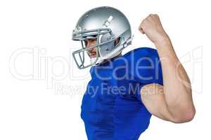 American football player looking away while flexing muscles