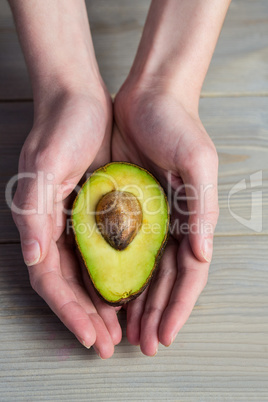 Woman showing fresh avocado