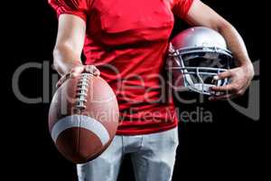 Mid section of sportsman showing American football while holding