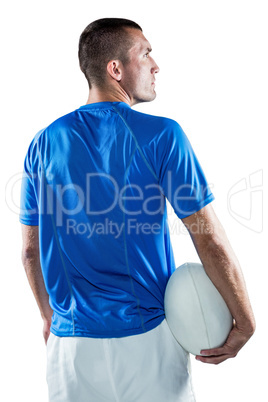 Rugby player looking away while holding ball