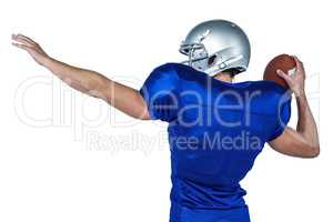 Rear view of American football player throwing ball