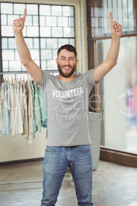 Man with arms raised standing in office