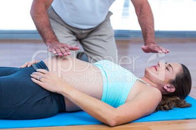 Therapist performing reiki on patient