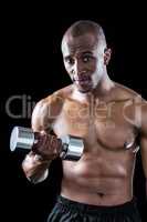 Portrait of athlete exercising with dumbbell