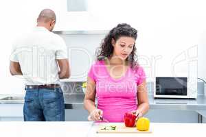 Pregnant wife chopping vegetables