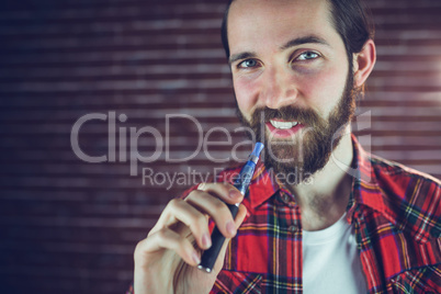 Portrait of smiling man with electronic cigarette