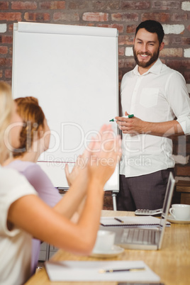 Businesswoman applauding male colleagues