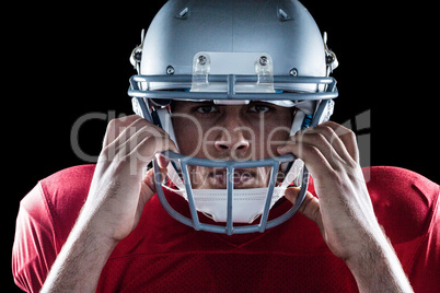 Close-up portrait of American football player holding helmet