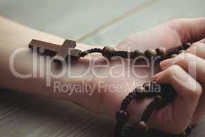 Woman holding wooden rosary beads