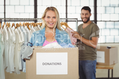 Portrait of woman holding donation box while standing