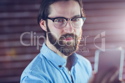 Confident hipster looking at cellphone