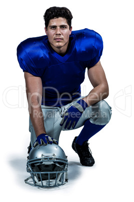 Portrait of confident American football player with hand on helm