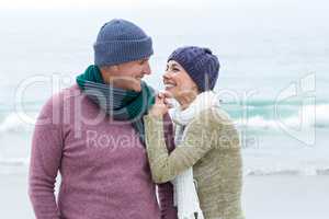 Smiling happy couple both wearing scarfs and hats