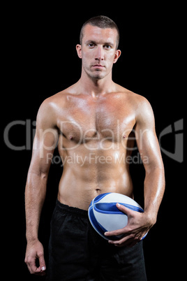 Confident shirtless sports player holding ball