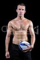Confident shirtless sports player holding ball