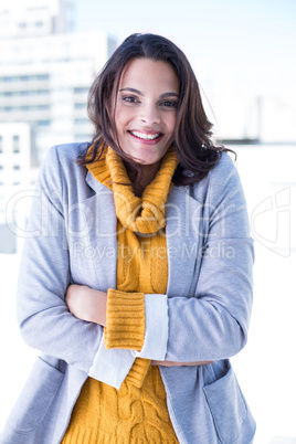Smiling beautiful brunette standing arms crossed