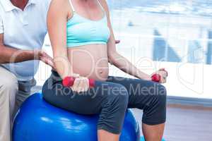 Mid section of pregnant woman exercising