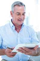 Businessman reading notepad while sitting