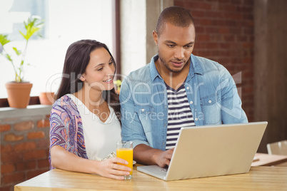 Businesswoman holding drink by male colleague