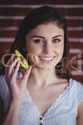 Woman showing fresh avocado