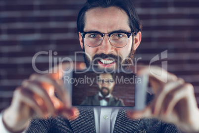 Portrait of smiling man taking picture of himself