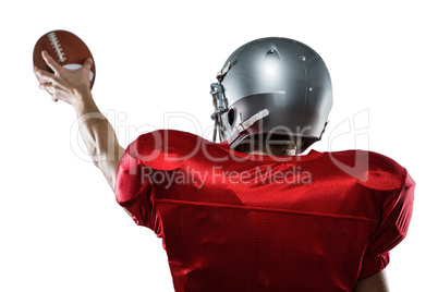 Rear view of American football player in red jersey holding ball