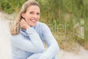 Smiling woman sitting on the sand