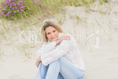 Woman sitting near the sandy hill