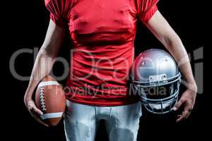 Mid section of sportsman holding American football and helmet