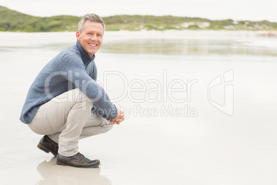 Man crouched down at the shore
