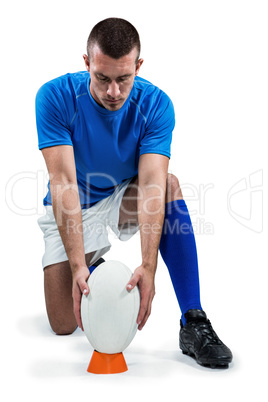 Full length of rugby player placing ball