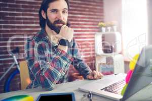 Portrait of confident businessman with graphic tablet and laptop