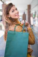 Portrait of smiling woman with shopping bag looking at camera