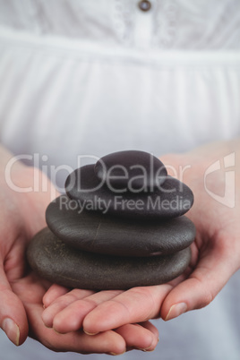 Woman holding black stones