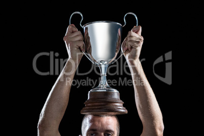 Successful rugby player holding trophy