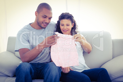 Young couple looking at baby clothing