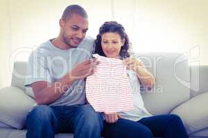 Young couple looking at baby clothing