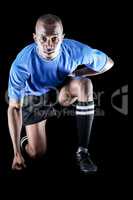 Portrait of confident sportsman kneeling