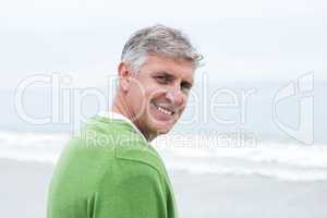 Smiling man standing at the shoreline