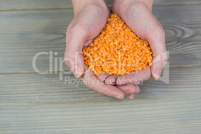 Woman showing handful of red lentils