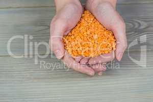 Woman showing handful of red lentils