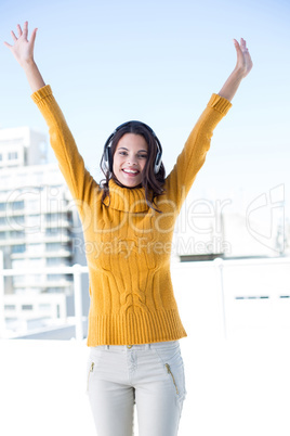 Happy woman listening music through headphones